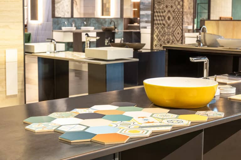 Bunte Fliesen und gelbes Waschbecken in einer Ausstellung