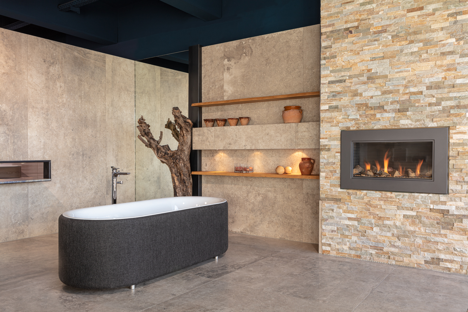 Ein modernes Badezimmer mit freistehender schwarzer Badewanne und Kamin.